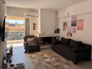 a living room with a couch and a fireplace at Sparkling dream in Saronida
