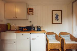 a kitchen with two chairs and a counter top at Shepherd's Hut - Jasmine in Haverfordwest