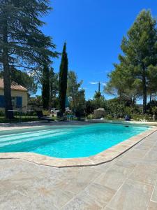 a swimming pool with blue water in a yard at La Margottière chez isa et titi in Rians