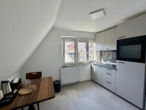 a kitchen with a wooden table and a refrigerator at AS Aparthotel in Schorndorf
