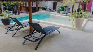 a group of chairs sitting next to a swimming pool at Hotel Diosa del Agua Bacalar in Bacalar
