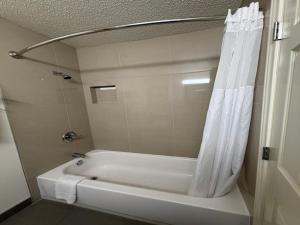 a white bath tub with a shower curtain in a bathroom at Everstay Living in Dallas +19 photos