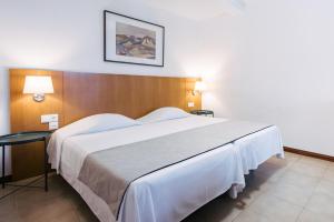 a large white bed in a hotel room at Murças74 - Studio Apartments in Funchal