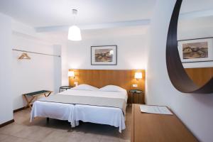 a bedroom with a white bed and a large mirror at Murças74 - Studio Apartments in Funchal