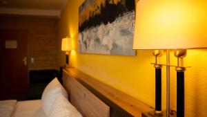a hotel room with a bed and a yellow wall at Maiers Hotel in Bayerisch Eisenstein +41 photos
