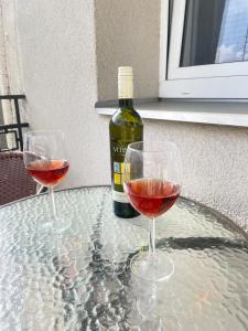 two glasses of wine on a table with a bottle of wine at Central Comfort Studio Walkup in Slezská Ostrava +4 photos