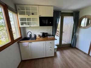 a kitchen with white cabinets and a sink at Lépcsősház in Nagymaros