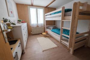 a room with two bunk beds and a kitchen at Gackernästli Emmental in Bärau