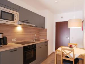 a kitchen with a sink and a stove and a table at Haus Gertrud in Carolinensiel