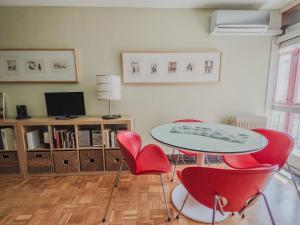 a living room with two tables and red chairs at Apartamento CENTRO HISTÓRICO Zorrilla 4 in Zamora