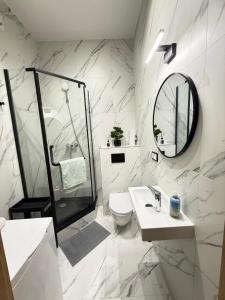a white bathroom with a toilet and a mirror at Exclusive Apartments Smolna in Warsaw +244 photos