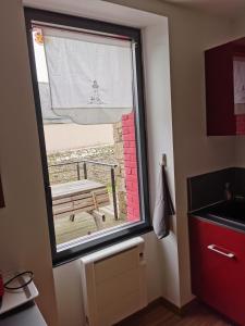 a window in a kitchen with a bench outside at La maison Kerserho in Plouhinec +11 photos