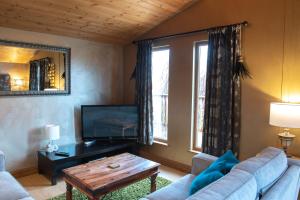 a living room with a couch and a tv and a table at Palomino Lodge - Still Rabbit - Hot Tub - Yorkshire in Selby