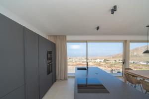a kitchen with a table and a view of the desert at Villa James by Aura Collection in Tindaya
