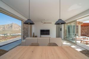 a dining room with a table and large windows at Villa James by Aura Collection in Tindaya