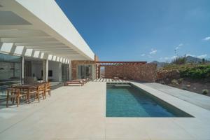 a patio with a table and chairs and a swimming pool at Villa James by Aura Collection in Tindaya +20 photos