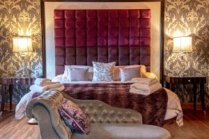 a bedroom with a large bed with a red headboard at Palomino Lodge - Still Rabbit - Hot Tub - Yorkshire in Selby +14 photos