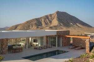 a house in the desert with a mountain in the background at Villa James by Aura Collection in Tindaya