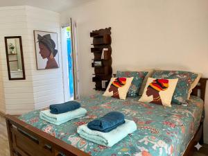 a bedroom with a bed with pillows on it at Studio accès piscine, plage à 50m in Le Gosier
