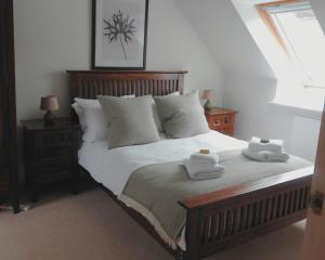 a bedroom with a bed with two towels on it at Bracken Cottage in Killean