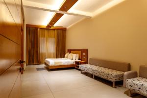 a hotel room with a bed and two benches at Vynza Resort Vythiri in Vythiri +38 photos