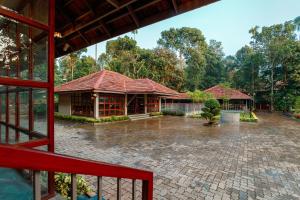 a house in the rain with a courtyard at Vynza Resort Vythiri in Vythiri
