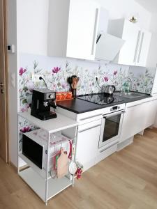a white kitchen with flowers on the wall at Apartmán Alicante in Dunajská Streda