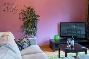 a living room with a couch and a flat screen tv at Beveren Lodge - Still Rabbit - Hot Tub - Yorkshire in Selby