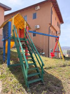a playground with a slide and a swing at Prestige Deluxe View Villa in Ilijaš