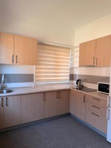 an empty kitchen with wooden cabinets and a sink at Prestige Deluxe View Villa in Ilijaš