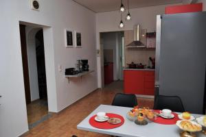 a kitchen and a table with plates of food on it at Art House by Helen in Soroni Rhodes in Rhodes Town