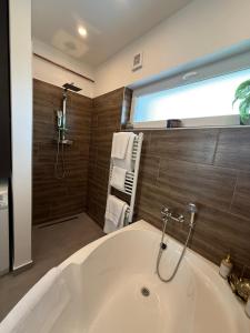 a bathroom with a white tub and a shower at Local-Lux Garden Residence A- 2 Bedrooms-Terrace in Kecskemét +35 photos