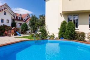 a swimming pool in front of a house at Bałtyk Resort in Rewal