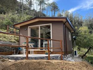 a tiny house with a porch and a deck at Villaggio Camping Valdeiva in Deiva Marina