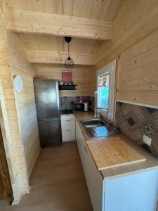 a kitchen with a refrigerator and a sink in a cabin at El Palmito Rural Home in Jerez de la Frontera