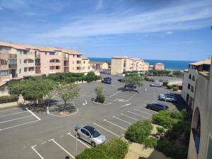 a parking lot with cars parked in a parking lot at Appt climatisé vues sur mer in Fleury