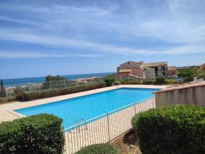 a large swimming pool in front of a house at Appt climatisé vues sur mer in Fleury