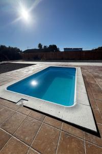 a swimming pool on a patio with a tile floor at El Palmito Rural Home in Jerez de la Frontera