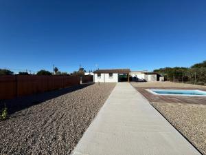 a sidewalk in front of a house with a fence at El Palmito Rural Home in Jerez de la Frontera