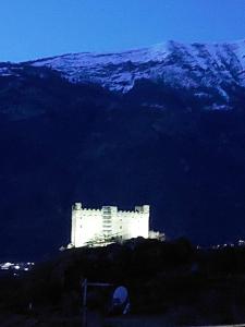 a white castle in front of a snow covered mountain at Pres du Chateau in Châtillon +3 photos