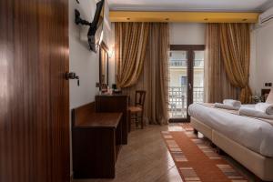 a hotel room with a bed and a desk and a bedroom at Filippos Hotel in Nea Moudania