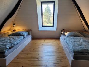 two beds in a room with a window at Ferienhaus Heilhecker in Brake