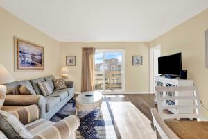 a living room with a couch and a tv at Lighthouse Point Rental 8B in Tybee Island