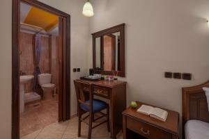 a bedroom with a desk and a bathroom with a sink at Filippos Hotel in Nea Moudania +32 photos