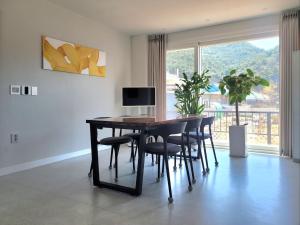 a dining room with a table and chairs and a window at Vong Stay 봉스테이 in Chilgok
