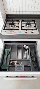 a kitchen sink with utensils and a stove at Vong Stay 봉스테이 in Chilgok
