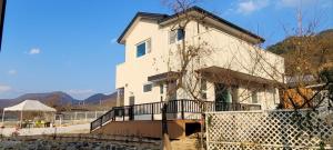 a white house with a fence in front of it at Vong Stay 봉스테이 in Chilgok