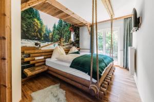 a bedroom with a swinging bed with a painting at Smileys Kinderhotel in Trebesing