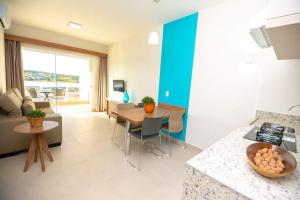 a kitchen and living room with a table and a couch at Ilhas do Lago in Caldas Novas
