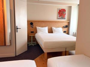 a hotel room with two beds and a door at Greet Hotel Colmar in Colmar +100 photos